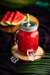 Jar with watermelon juice and ice cubes