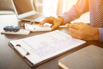 Car dealers have brought out documents and calculators to calculate interest rates and notify car payment to customers before signing purchase contract for accuracy. using calculator to get accurate