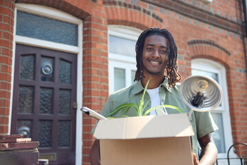 Portrait Of Young Man Or Student Moving Into House Flat Or Apartment Whilst Studying At University Or College