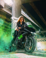 Woman driving her racer motorcycle. Green clouds of smoke from the wheel. Transportation and speed...