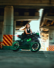 Woman driving her racer motorcycle. Green clouds of smoke from the wheel. Transportation and speed...