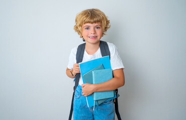 Primary school smiling boy girl with backpack looking smiling to camera holding blue book and exercise. Copy space for advertising blank concept. Back to school. education