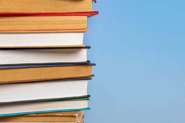 Stack of books in the colored cover lay on blue backround. Education learning concept