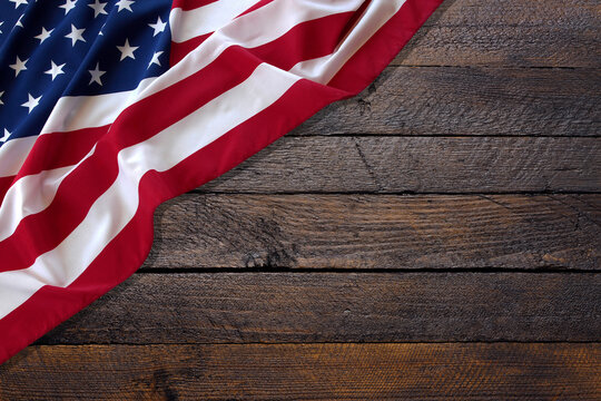 Top view overhead America United States flag, memorial remembrance and thank you of hero, studio shot with copy space on wooden table background, USA holiday Veterans or Independence day concept.