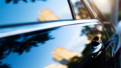 The sunset is reflected  on black new car