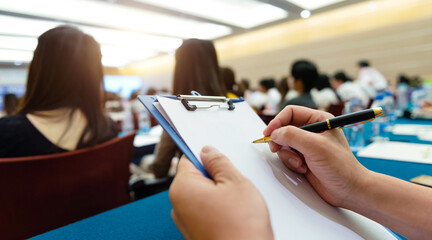 People writing on document at a business seminar