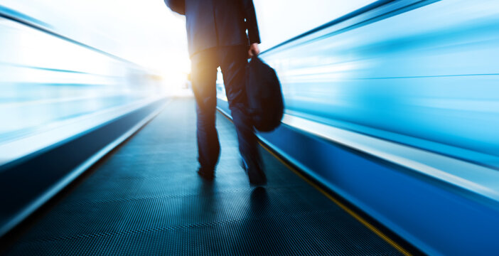 Business people walking at moving escalator in airport