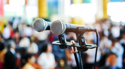Closeup microphone in auditorium with blurred people in the background