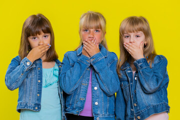I will not say anyone. Little girls closing mouth with hands, looking intimidated scared at camera,...