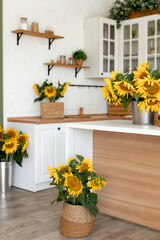 Vase with beautiful yellow sunflowers in the kitchen