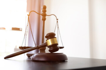 gavel wood and Brass court scales are used to decorate a table in a legal advisor office for...