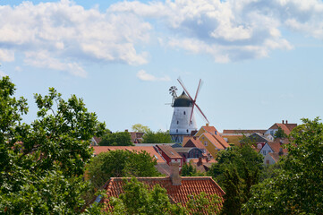 Rote Dächer und Windmühle der Ortschaft Gudhjem auf der dänischen Ostseeinsel Bornholm im Sommer...