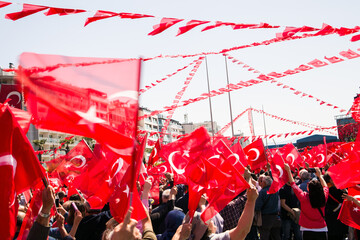 Unknown people, with their backs turned, hands up, at a celebration with Turkish Flags.