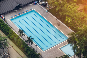 Top view of clear blue water in large swimming pool with tree. Top view of swimming pool in the park view resort. Aeria