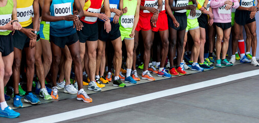 Legs of multi-ethnic athletes before marathon start - obrazy, fototapety, plakaty