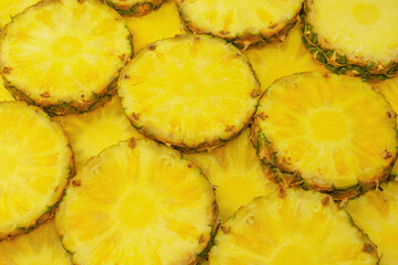 Pineapple juicy yellow slices as a background.