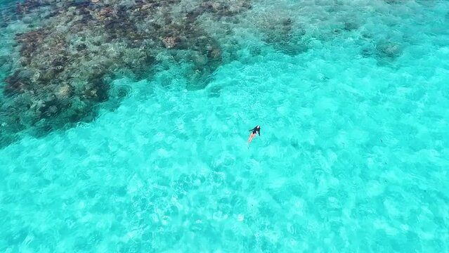 Woman floating in most beautiful tropical clear turquoise water