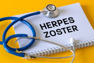 Medical stethoscope, white notebook with the inscription Herpes Zoster, yellow background,...