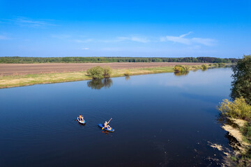 Funny man and woman floats on supboard on lake, sun light. Friends surfer on paddleboard. Concept summer active sport on water