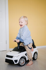 Cute little boy driving children's electric toy   