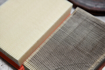New and old dirty automotive engine air filter on metal table. Auto repair concept.