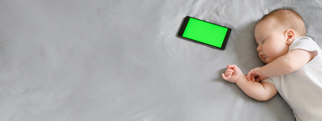Banner,cute baby sleeps in his crib next to the phone, chroma key. A lullaby is playing for baby...