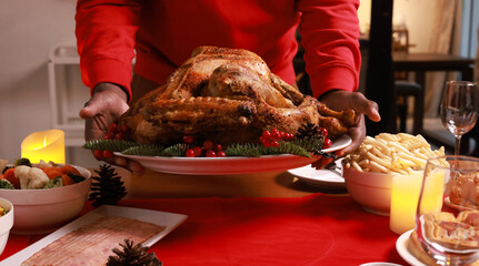 Close up hand holding Baked chicken serve on luxury dining table, Christmas eve celebration or party preparation concept ,roasted Chicken. Christmas and New Year food concept