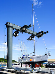 The yacht lifted ashore by a sailboat lift for the maintenance of the underwater part of the hull