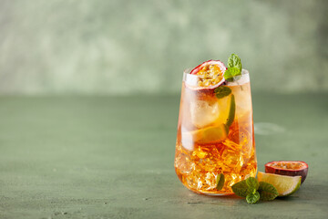 Fruit ice tea. Refreshing summer drink with syrup, passion fruit, lime, mint and ice. Glass with cold and healthy beverage