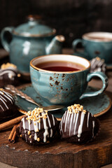 Tasty chocolate mini cakes  and cup of  tea on  dark table
