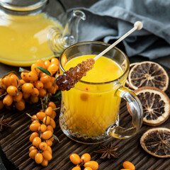 Glass cup of sea buckthorn tea on  dark background