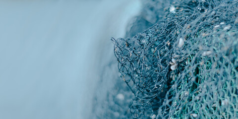blauer  Hintergrund mit viel Freifläche rechts ein Fischernetz schwache Schärfentiefe - obrazy, fototapety, plakaty
