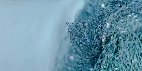 Foto op Canvas blauer  Hintergrund mit viel Freifläche rechts ein Fischernetz schwache Schärfentiefe © URS.INHO