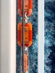 Vertical shot of reflecting safety boats on board of a cruise ship