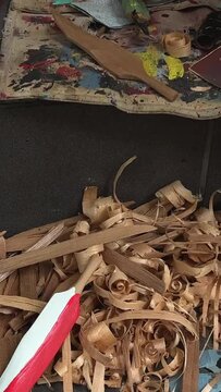 on the street man with beard of Indian appearance first people of Canada locals carving feather Poor people poverty close-up details of his work sawdust hands creativity crafting Vancouver Canada 2023