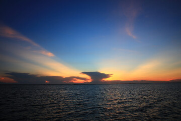 Fototapeta na wymiar Long exposure to Beautiful rock on the sea against the twilight dark sky.