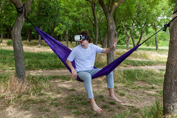 Young guy resting in a hammock in nature