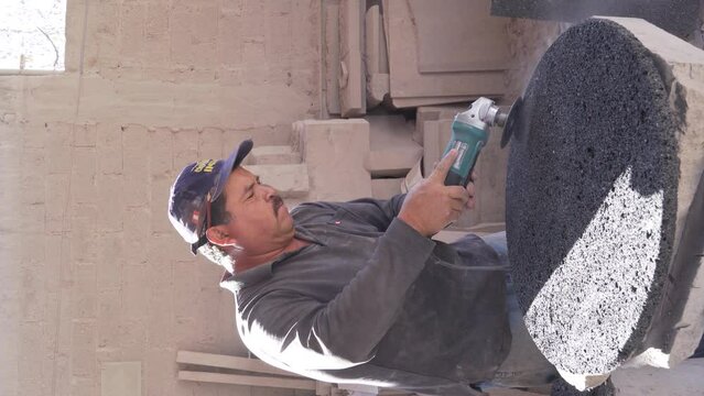 large latino man, hand cutting stones in artisan quarry and marble workshop