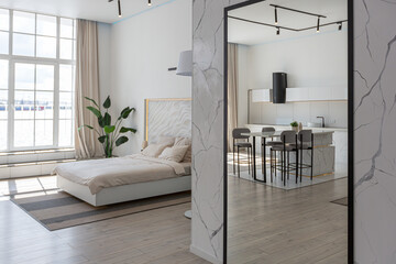 minimalistic modern luxury design of an expensive house with marble trim on a sunny day. white walls with plaster, parquet, decorative lighting and no one inside