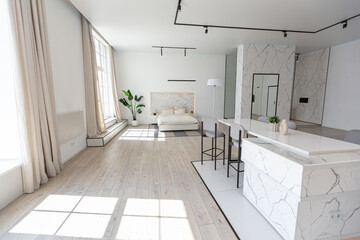 minimalistic modern luxury design of an expensive house with marble trim on a sunny day. white walls with plaster, parquet, decorative lighting and no one inside