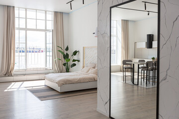 minimalistic modern luxury design of an expensive house with marble trim on a sunny day. white walls with plaster, parquet, decorative lighting and no one inside
