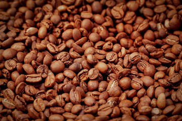 Fototapeta premium Spilled roasted brown coffee beans heap,pattern, close-up,background,texture