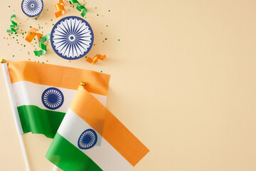 Wishing you joy on India Independence Day. Top view shot of national flags, patriotic confetti, ashoka wheels on pastel beige background with empty space for advert or text