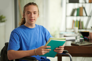 Portrait of high school student with disability studying in library