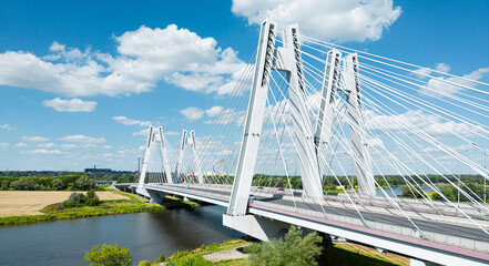 Modern suspension bridge on the outskirts of Krakow. Bird's-eye view shot by a drone. Cardinal Franciszek Macharski Bridge - obrazy, fototapety, plakaty