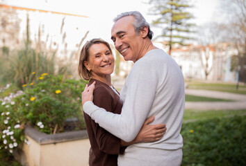 Romantic Mature Spouses Embracing Smiling At Camera In Park Outside