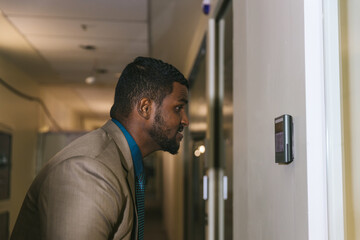 Man using face scanner to unlock door in office building. Access control facial recognition system....