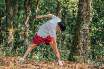 young sporty man warming up or stretching outdoors, exercising
