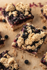 Baked oatmeal squares with fresh blueberry close up on beige parchment paper