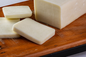 sliced buffalo mozzarella bar on wooden board